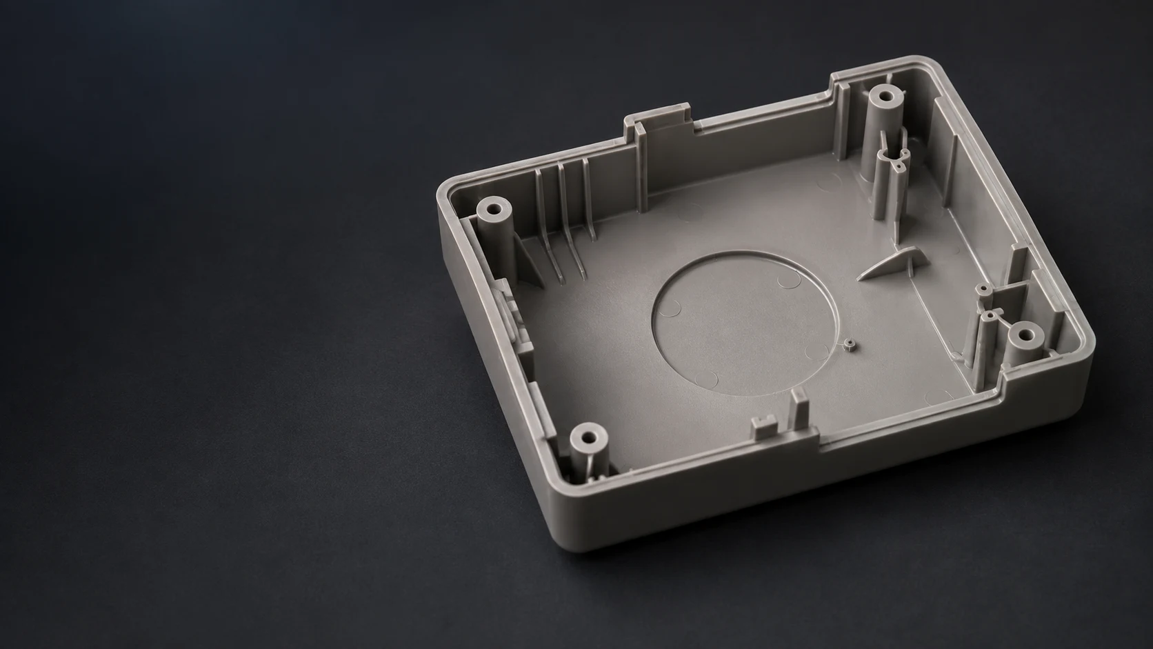 Conceptual close-up of a generic molded enclosure with ribs, bosses, and ejector-pin features.